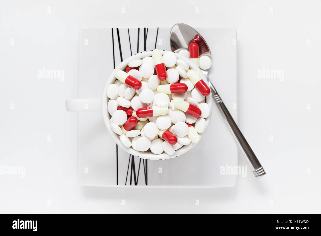 Tazza di caffè pieno di pillole misti Foto Stock