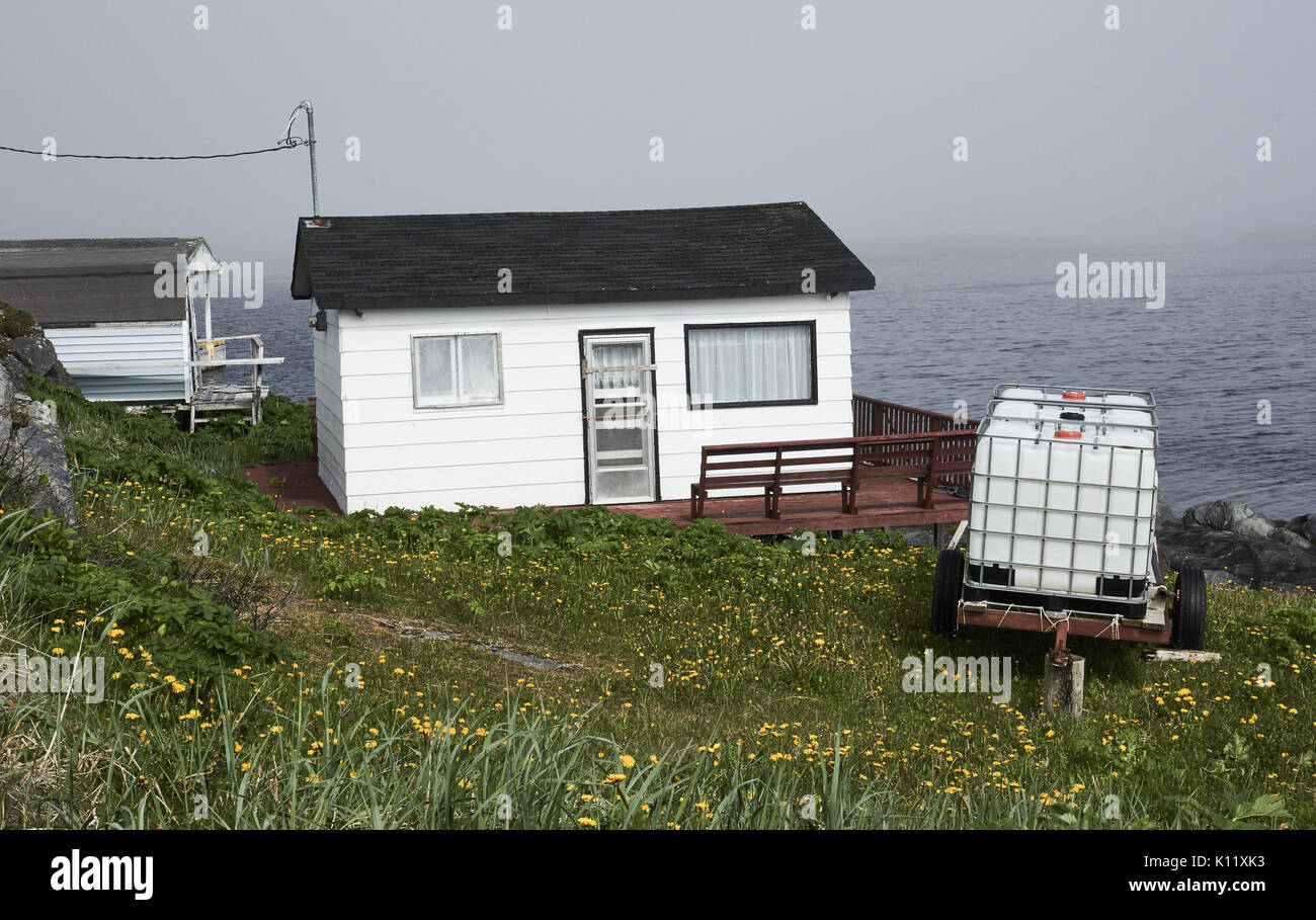 Contenitori di deposito di acqua nel giardino della casa di legno sopra l'Oceano Atlantico, Terranova, Canada Foto Stock