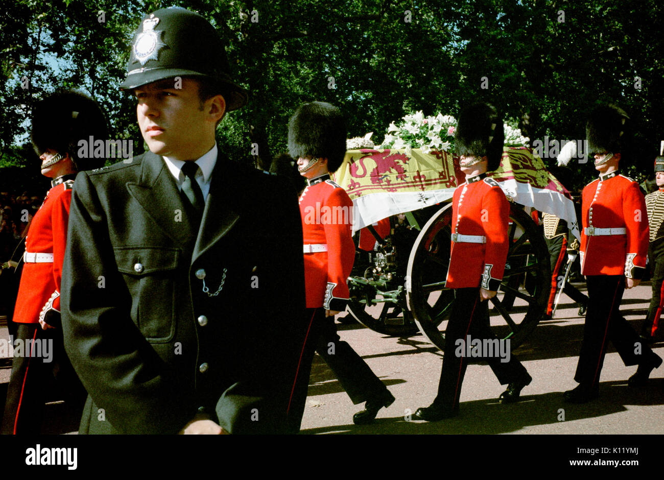Londra, UK, 6 settembre, 1997. Funerali di Diana, principessa di Galles. La principessa Diana la bara drappeggiati con il royal standard è mostrato di essere trasportati su un carrello pistola accompagnato da otto membri delle guardie gallesi come il corteo funebre rende il modo lungo Horse Guards Road. Foto Stock