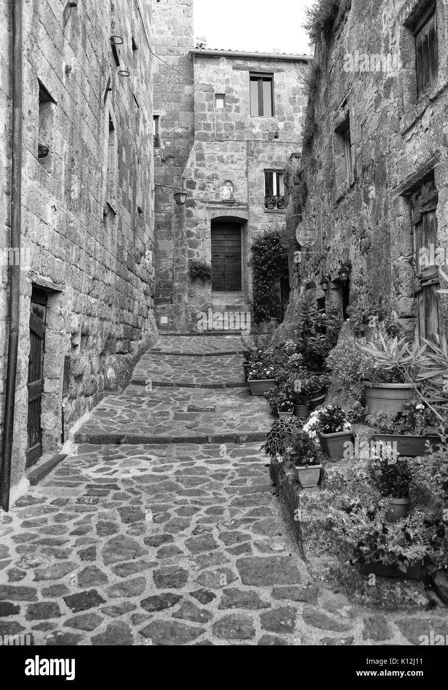 Bellissima vista del vicolo idilliaco modo nel famoso borgo di Civita di Bagnoregio vicino al fiume Tevere valley, Lazio, Italia. In bianco e nero Foto Stock