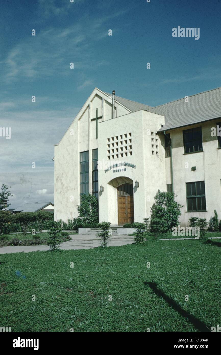 Edificio in pietra bianca con croce, su un grande prato verde, contro un cielo blu, al Tokyo Bible Seminary, Tokyo, Giappone, 1952. Foto Stock