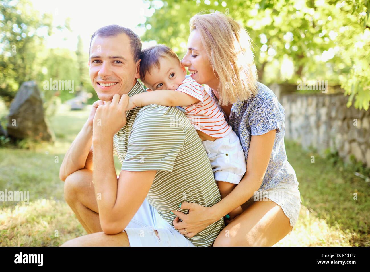 La famiglia felice sorridente giocando in estate park. Foto Stock