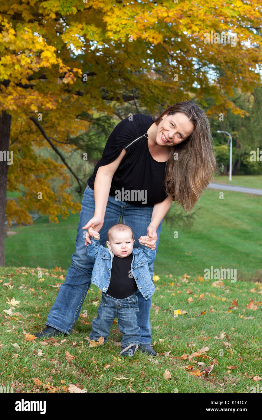 La madre aiuta il bambino a camminare Foto Stock