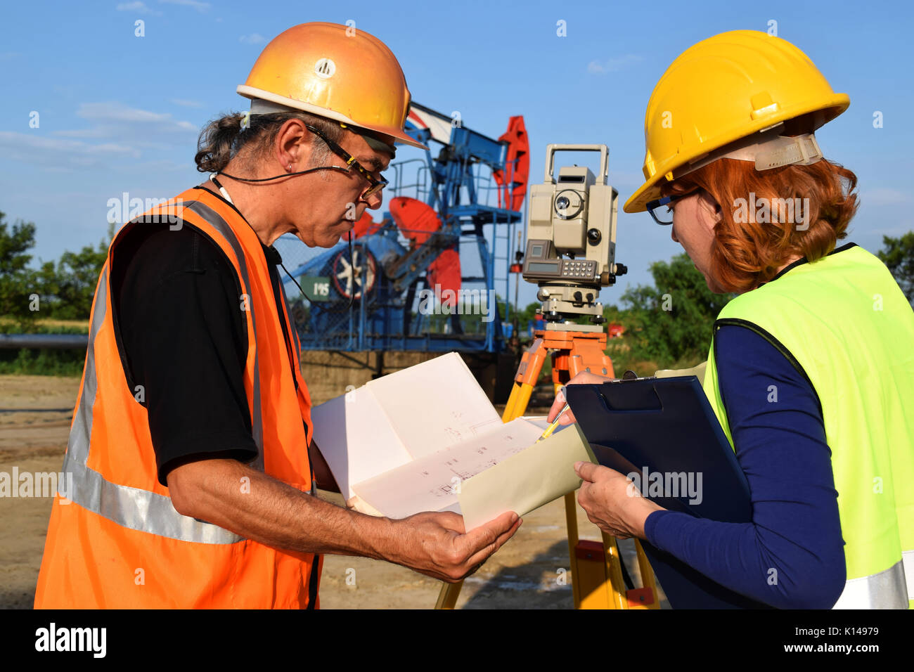 Due periti al lavoro e olio greggio pompa in background Foto Stock