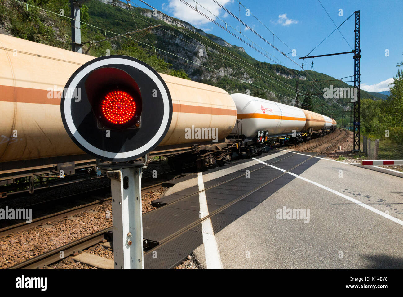 Treno veloce e un segnale di traffico rosso mostra / lampeggiante / luci di avvertimento per le auto a una ferrovia francese ferrovia ferrovia automatica passaggio a livello in Francia. Foto Stock