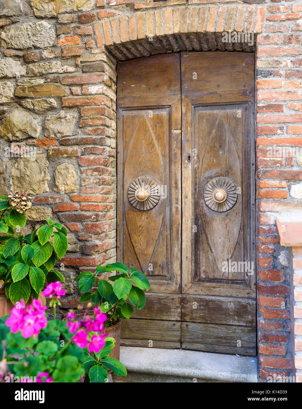 Vecchia porta di legno sul muro di pietra Foto Stock