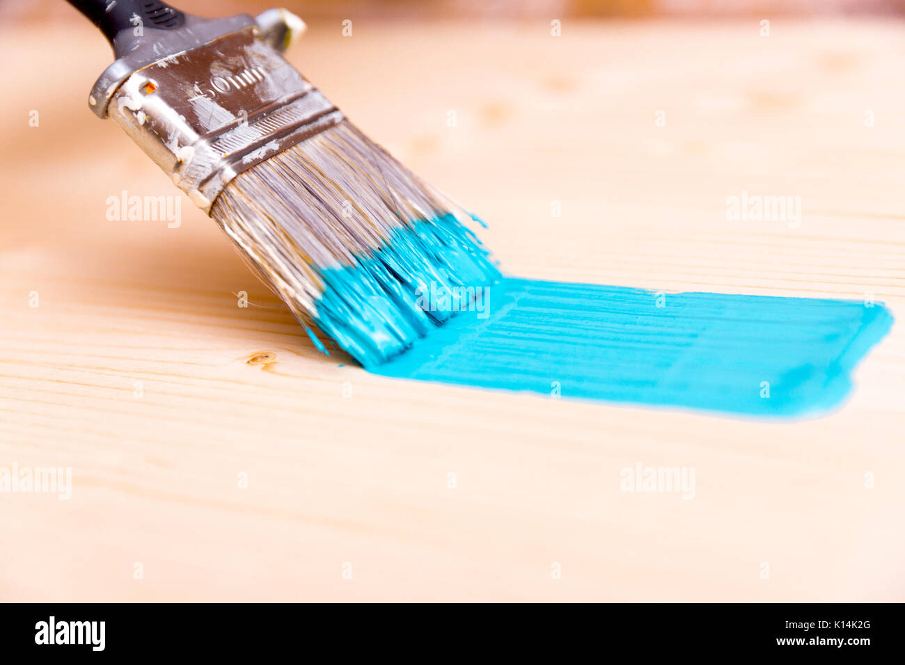 Processo di verniciatura del pannello di legno con il pennello e la vernice di color turchese Foto Stock