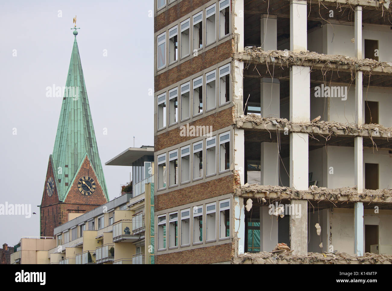 Close-up di demolito edificio per uffici con il campanile di una chiesa in background Foto Stock