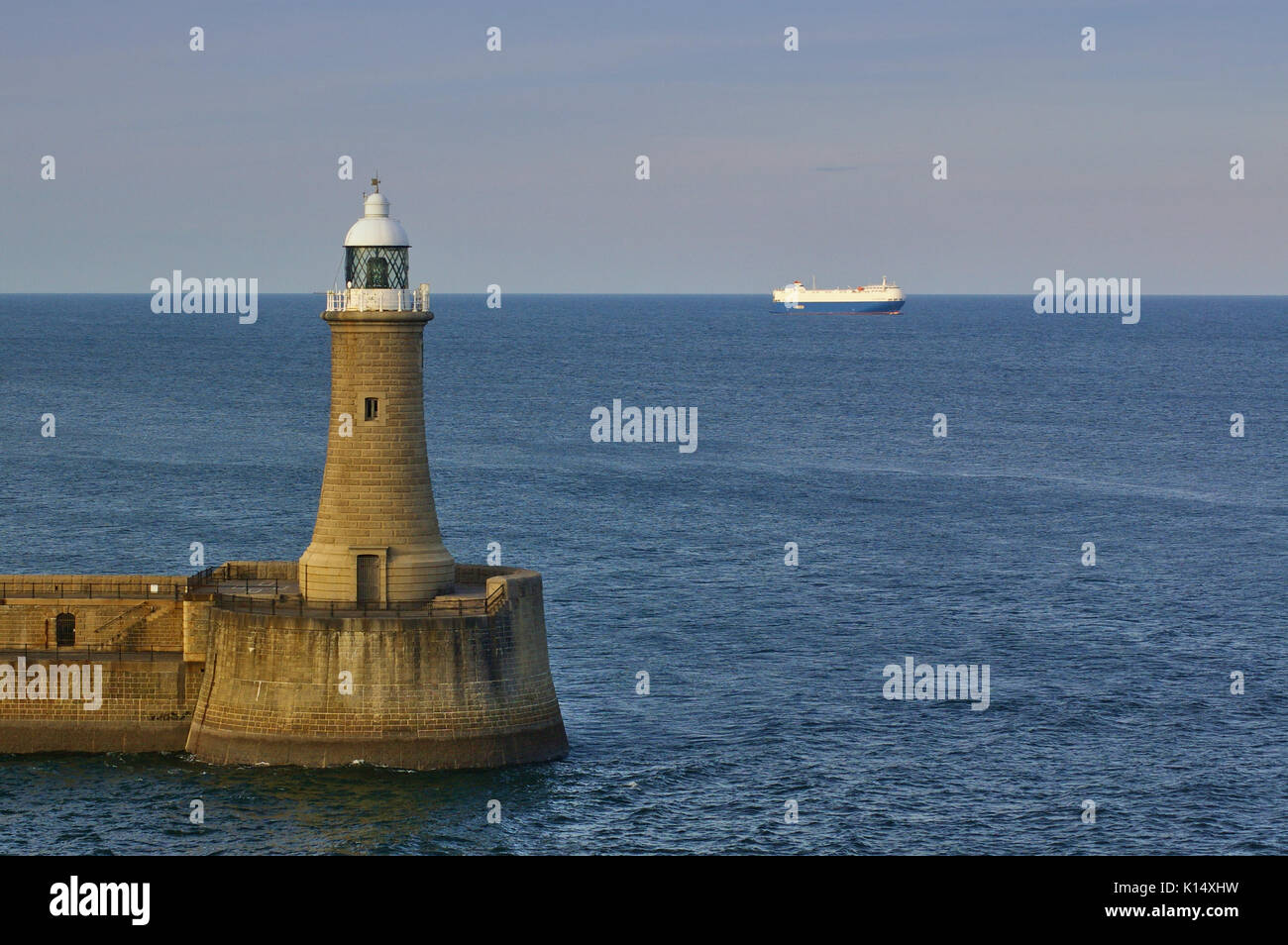 Faro alla fine del frangiflutti del tyne estuario con nave in background Foto Stock