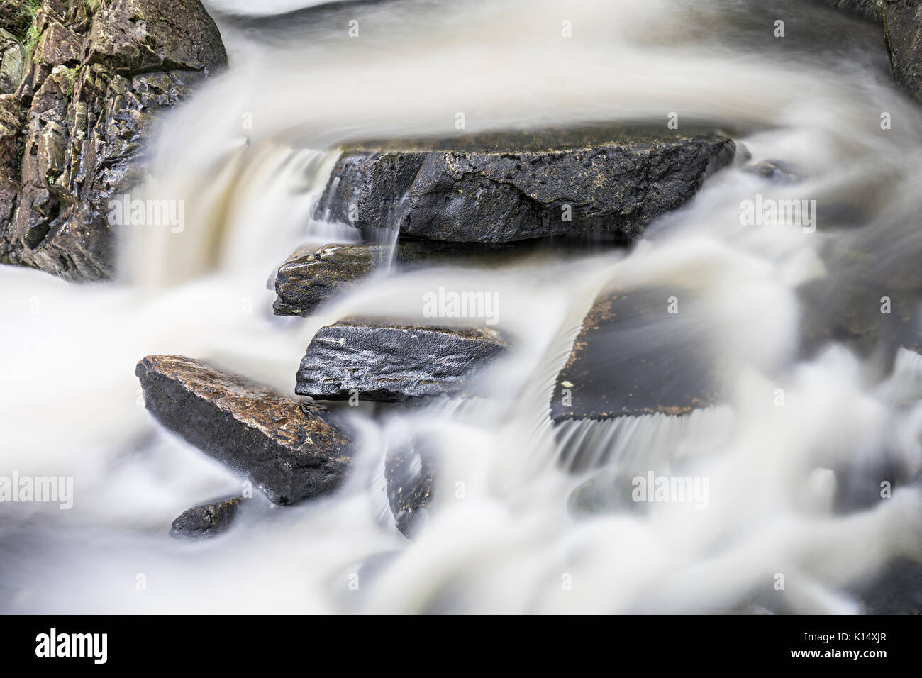 Le rocce in acqua fluente, Rhaeadr Ddu cascate, Ganllwydd, Coed Ganllwydd Riserva Naturale Nazionale, Parco Nazionale di Snowdonia, Gwynedd, Wales, Regno Unito Foto Stock