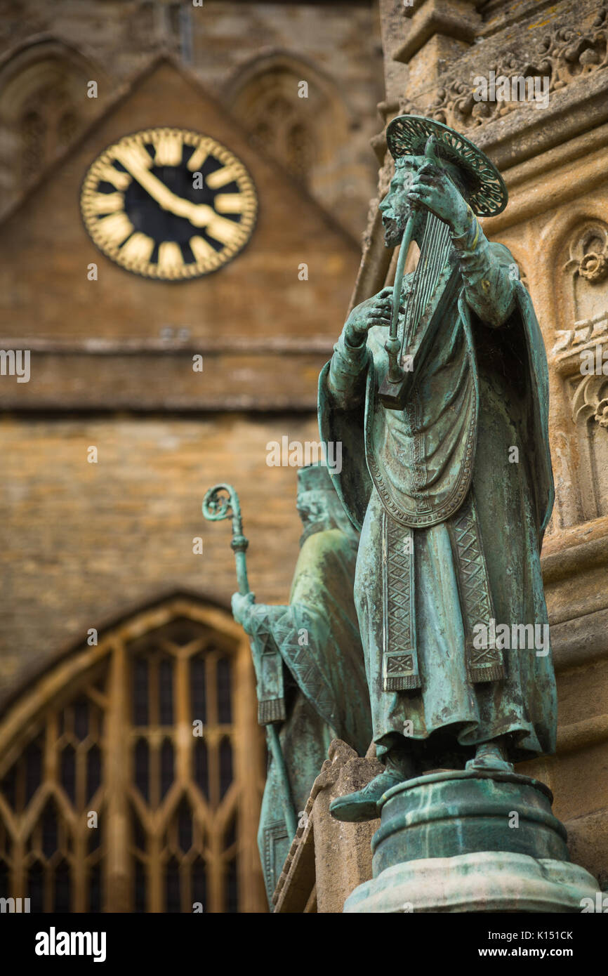 Statua religiosa di San Aldhelm suona l'arpa sul Digby Memorial al di fuori della chiesa abbaziale di Santa Maria Vergine (Sherborne Abbey), Sherborne, Dorset Foto Stock