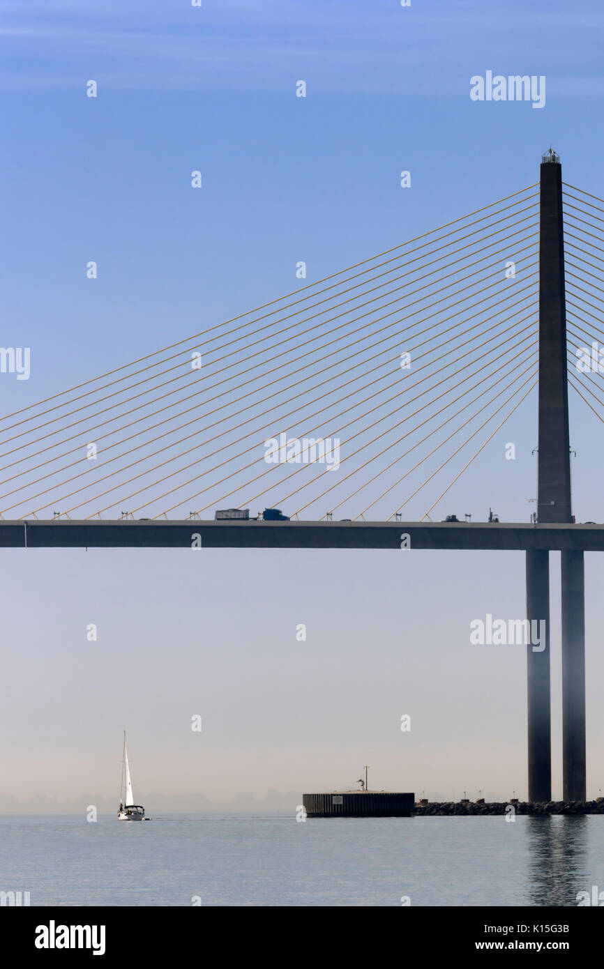 Una barca a vela passa sotto il Bob Graham Sunshine Skyway Bridge, Baia di Tampa, Florida Foto Stock