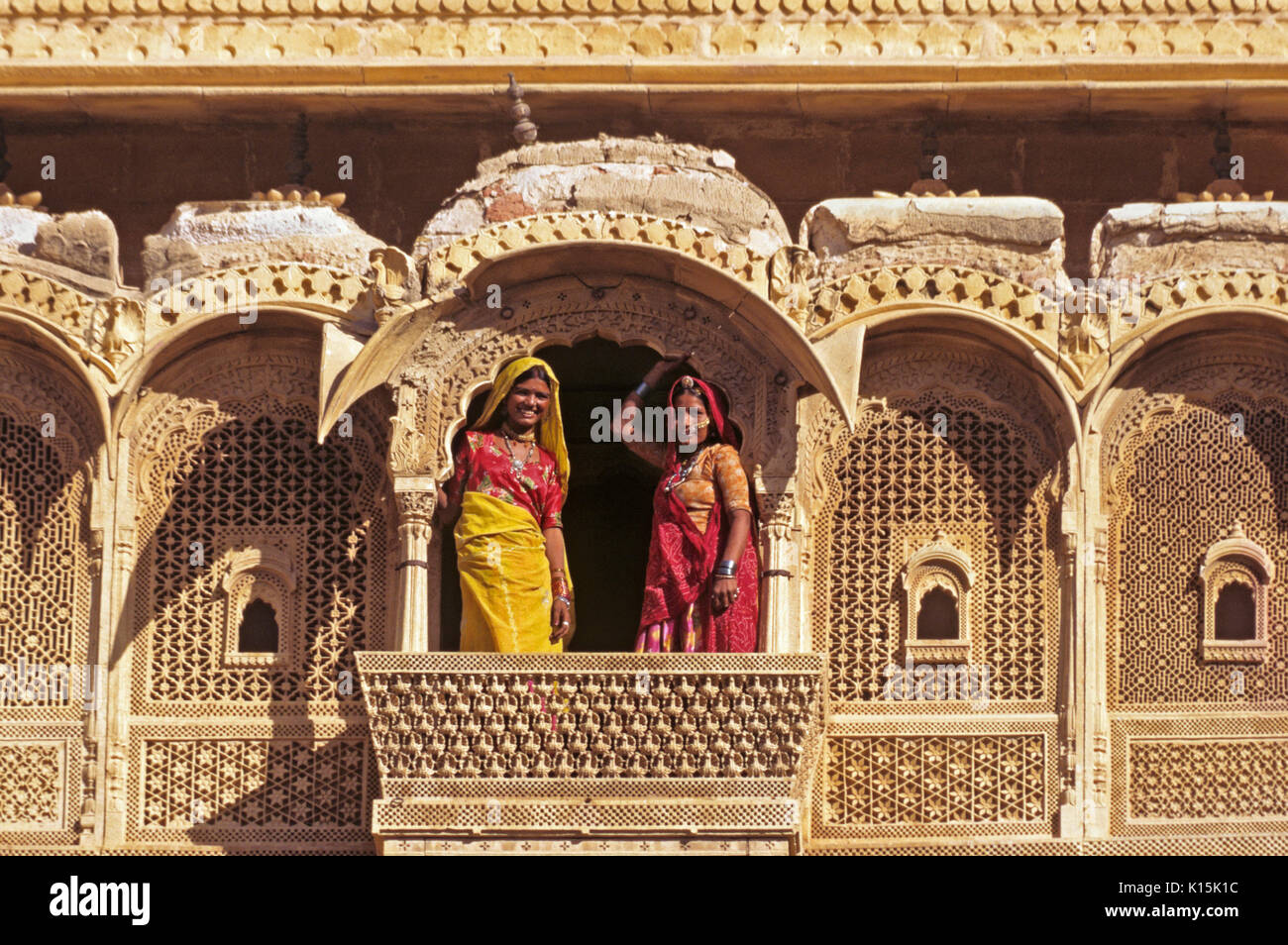 Le donne su intricate sculture di pietra arenaria balcone in Jaisalmer Fort, Jaisalmer, Rajasthan, India Foto Stock