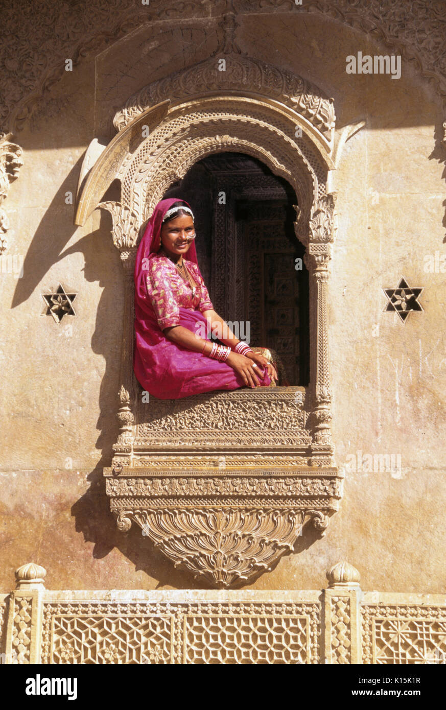 Donna seduta nella finestra di Patwon-Ki Haveli (Casa dei Mercanti di Brocade), Jaisalmer, Rajasthan, India Foto Stock