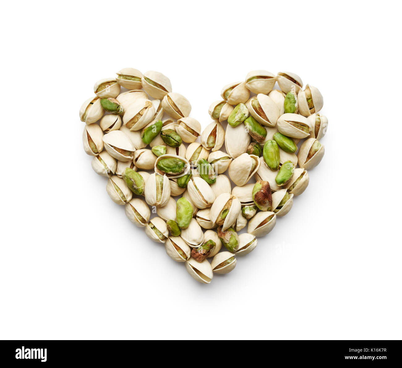 I pistacchi formando un cuore-forma isolata su bianco Foto Stock