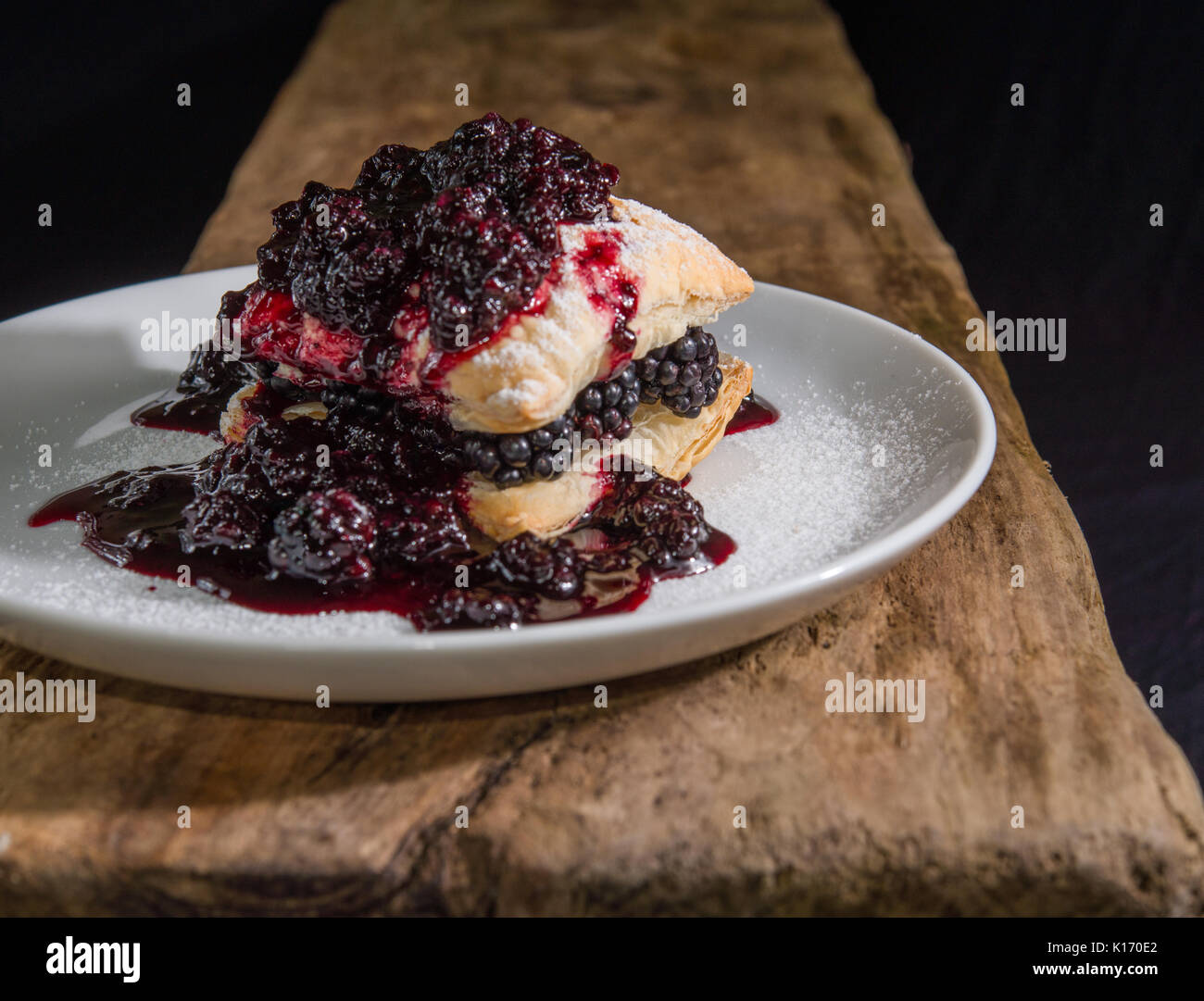 Fotografia di cibo - pasta sfoglia le piazze con fresco di more e marmellata servita su una piastra bianca Foto Stock