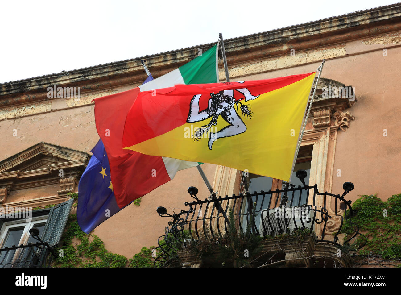 Sicilia, nel centro storico di Agrigento, in Piazza Piradello, siciliano bandiera regionale presso il municipio, il Palazzo Comunale Foto Stock