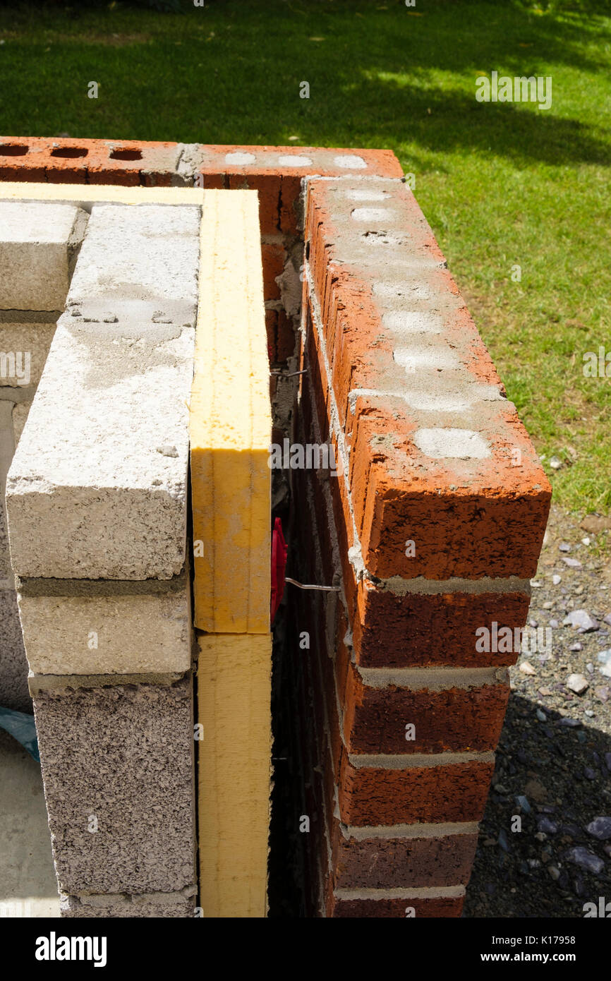 Isolamento interno di una nuova parete di cavità con distanziali tra mattoni e blocchi di brezza su una veranda esterna parete nana. Regno Unito, Gran Bretagna Foto Stock