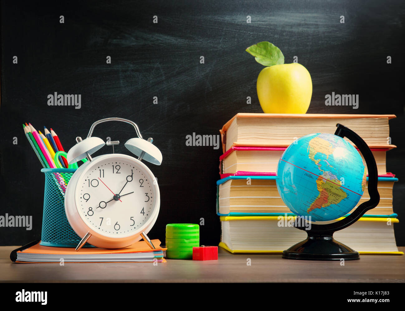 Accessori per la scuola sulla tavola con sfondo blackboard Foto Stock