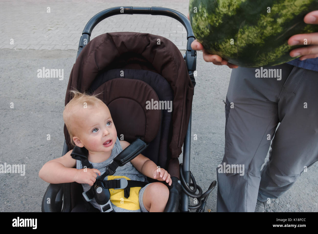 Genitore in possesso di cocomero e camminare con il bambino Foto Stock