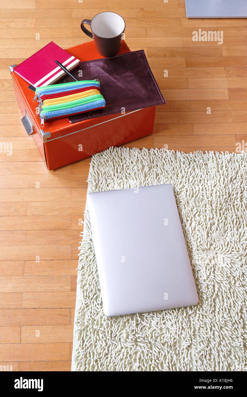 Laptop e libri sul pavimento per i compiti di scuola Foto Stock