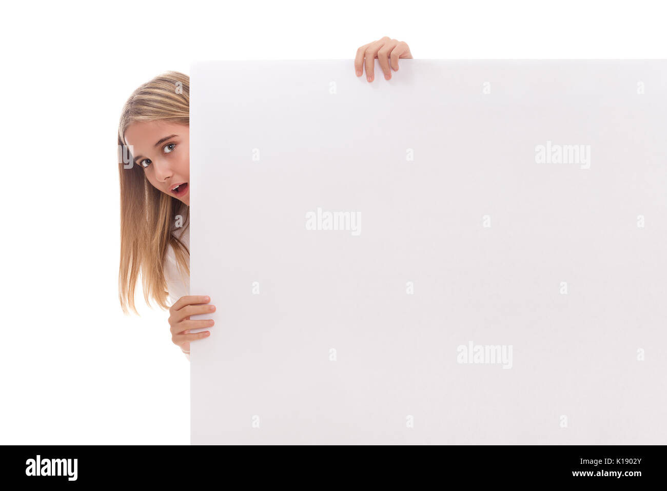 Sorpreso ragazza giovane è fuoruscita dal lato del bianco banner bianco su sfondo bianco Foto Stock