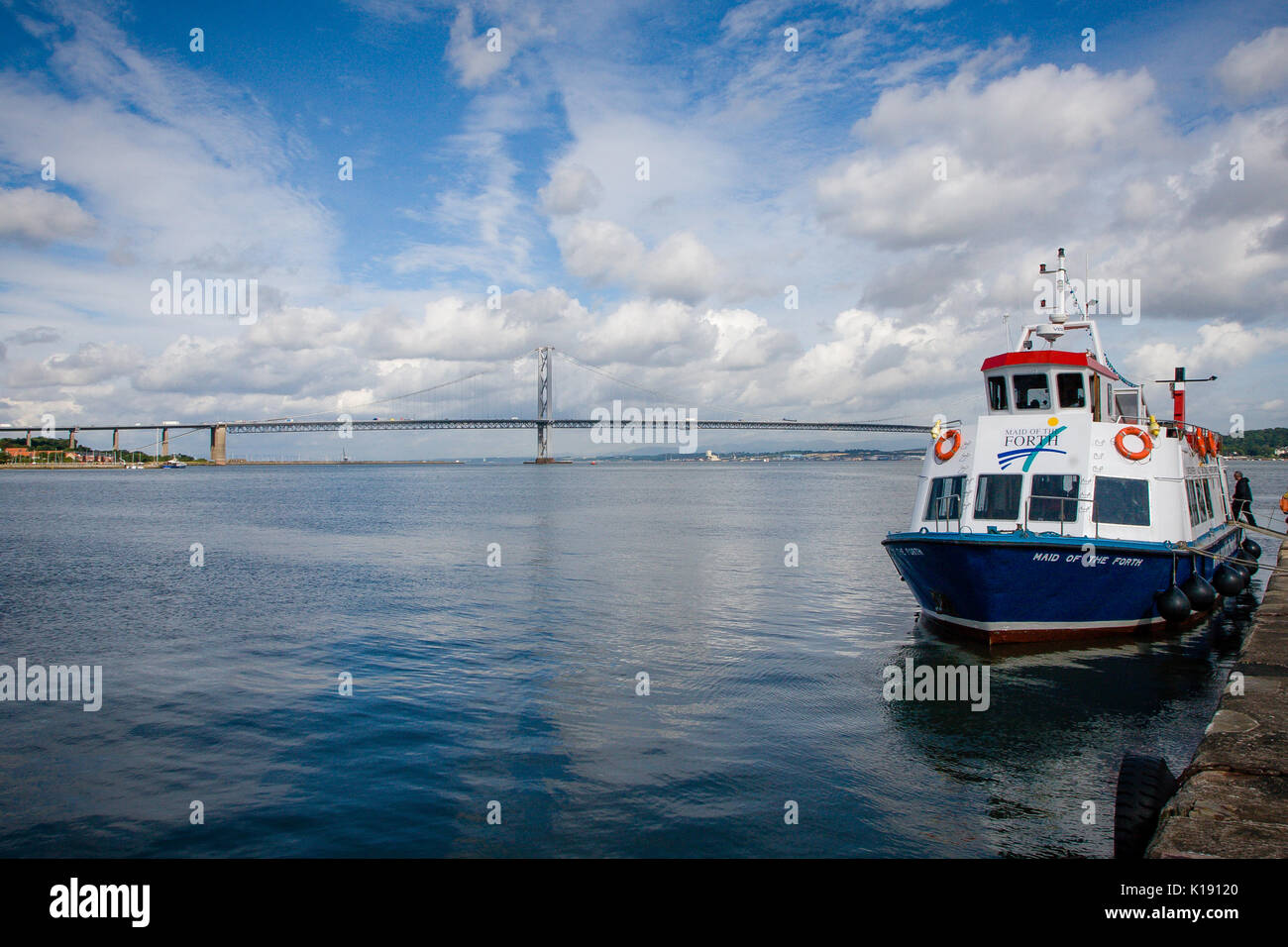 La domestica della via traghetto ormeggiata sulla hawes molo del Firth of Forth a south queensferry con Forth Road Bridge in background, Edimburgo Foto Stock