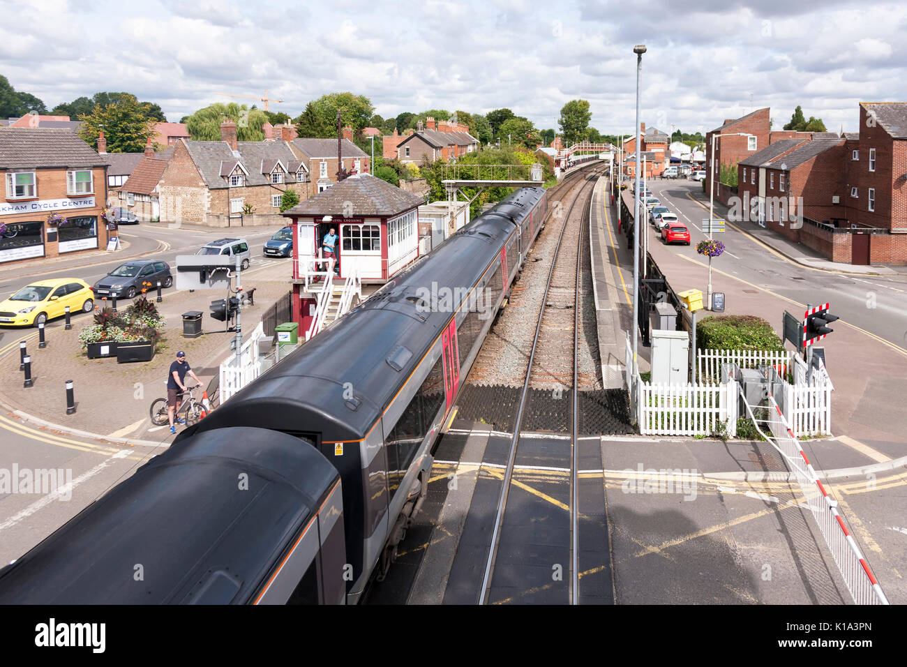 Treno diretto arcoss passaggio a livello in stazione a Oakham, Rutland.. U.K. Foto Stock