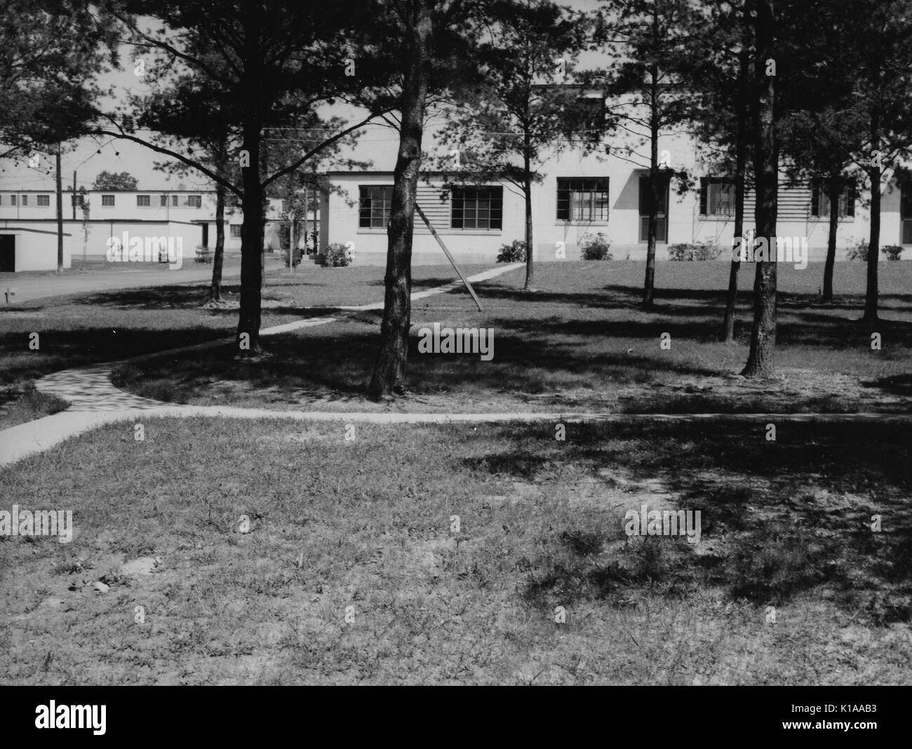 Campus con percorsi a piedi, alberi e tentacolare di edifici istituzionali in background, Greenbelt, Maryland, 1937. Dalla Biblioteca Pubblica di New York. Foto Stock