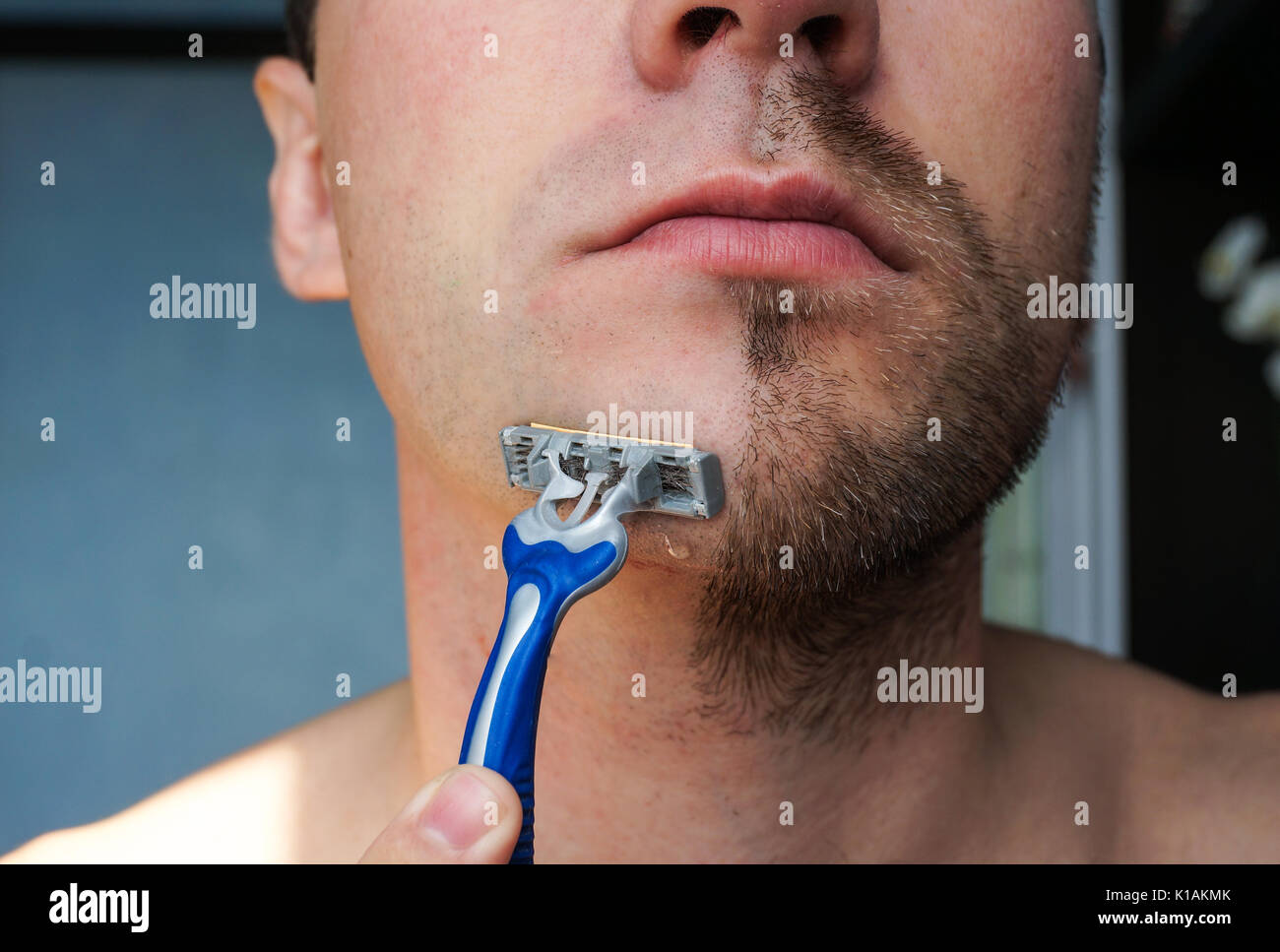 Maschio off radere la metà della barba. Mento closeup con un rasoio per una pelle  liscia Foto stock - Alamy