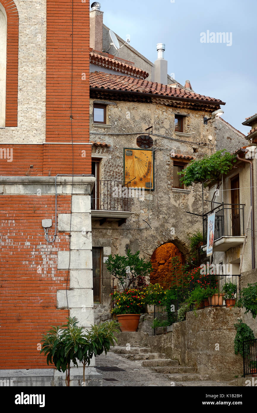 Suggestivi angoli del paese italiano. Vista di un antico edificio in muratura con passaggio illuminato e un'antica meridiana per la misurazione del tempo. M Foto Stock