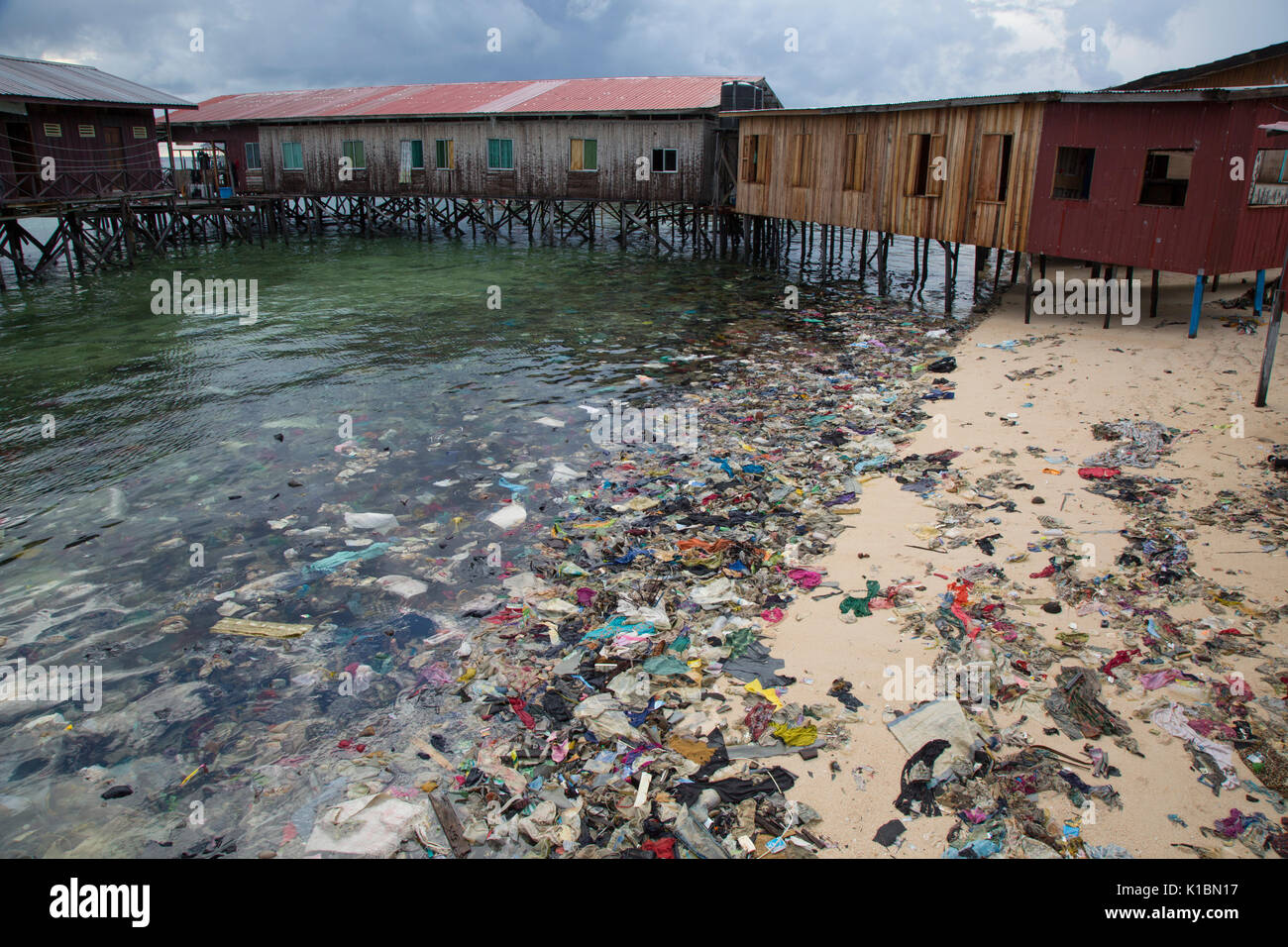 Immondizia di plastica e di altri rifiuti copre una spiaggia di fronte al bilancio dive resort sull'isola Mabul, Borneo Foto Stock