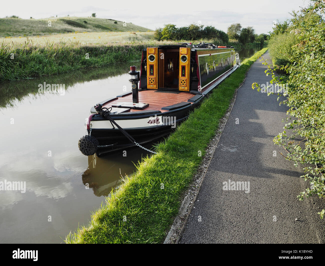 Tradizionale narrowboat dipinta in stile rimorchiatore ormeggiato in campagna Foto Stock