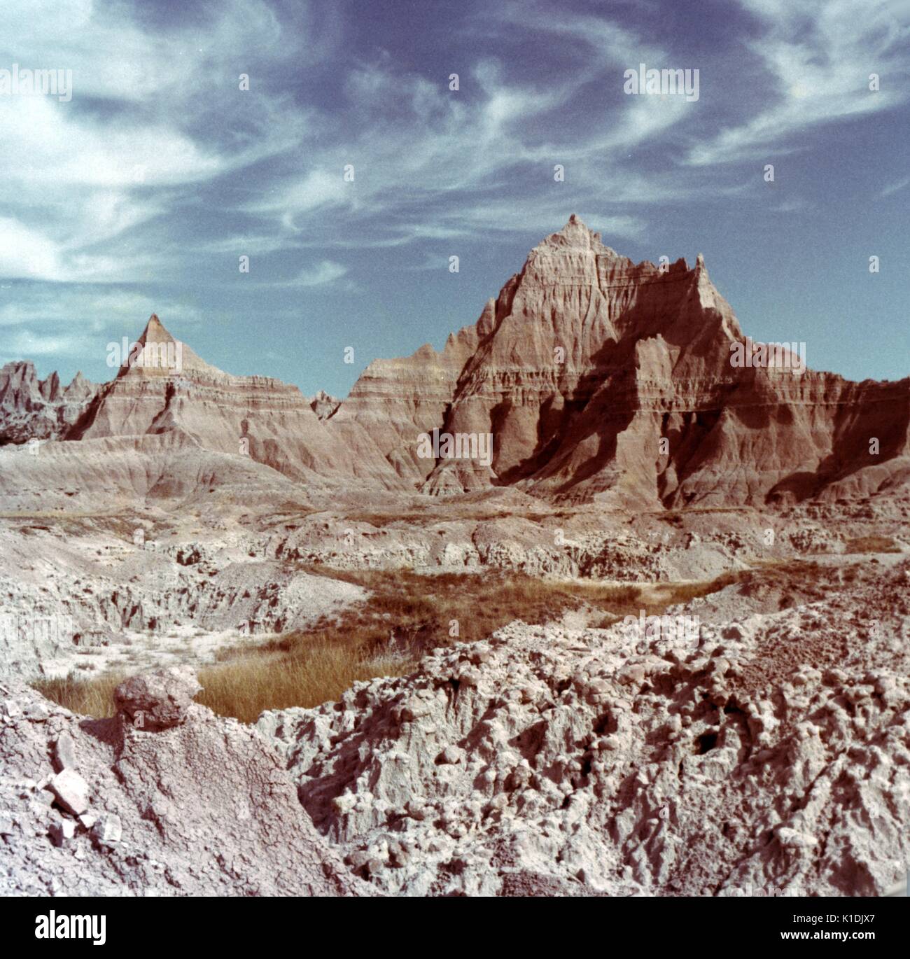 Vette erose con cielo blu e nuvole di whisky, Badlands National Park, South Dakota, 1975. Foto Stock