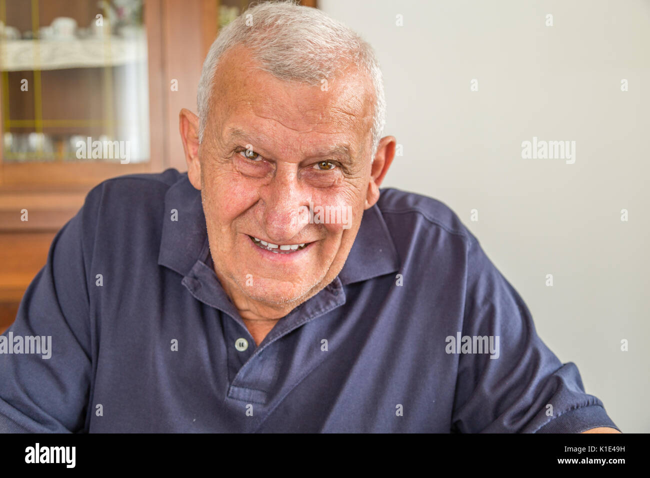 Il vecchio uomo sorridente dentro la sua casa Foto Stock
