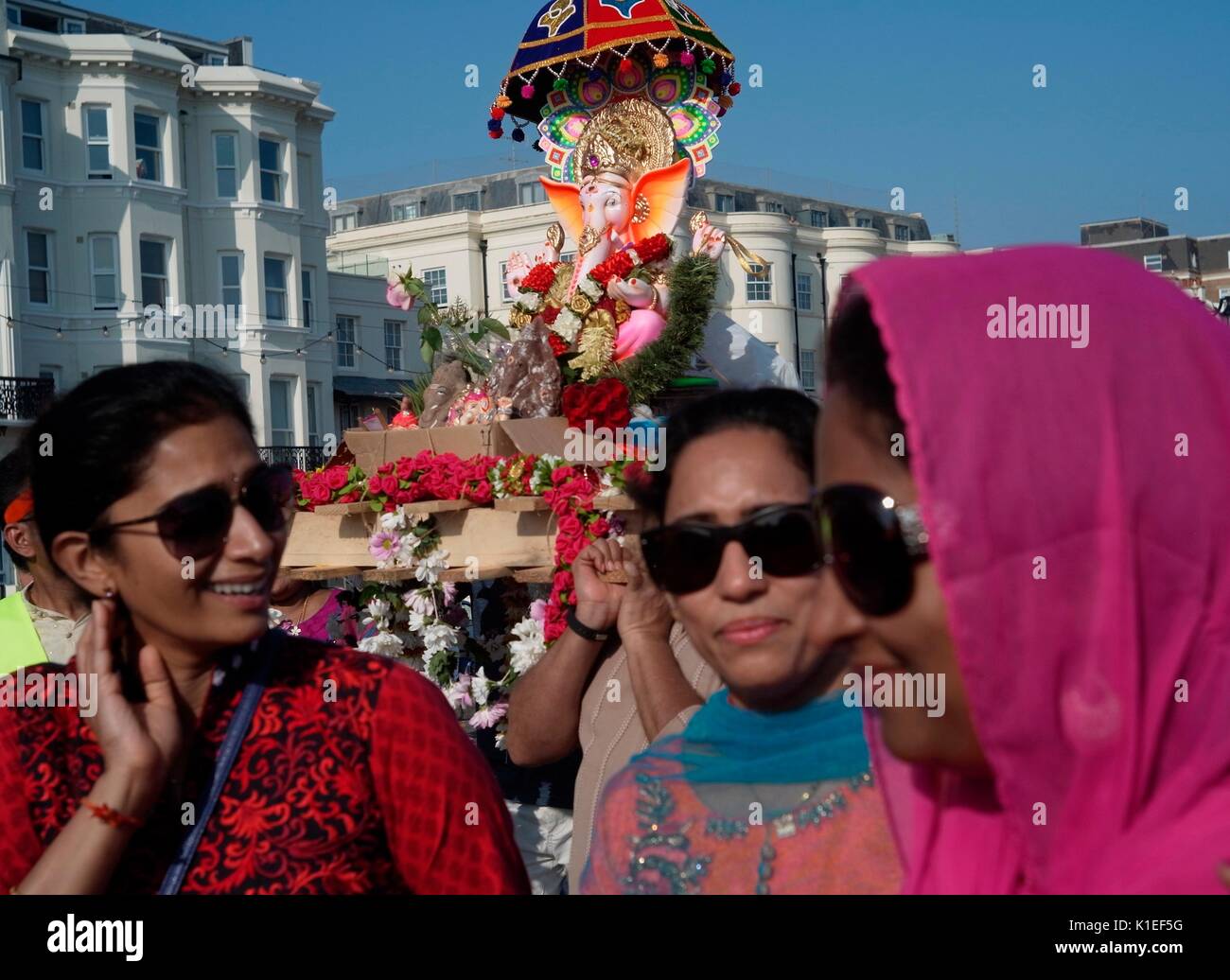 Worthing, Regno Unito. 27th ago 2017. Festeggiamo il Ganesh Festival nel Regno Unito - i membri della comunità indù locale portano un modello di Lord Ganesh lungo la spiaggia di fronte al canale inglese. Conosciuta anche come Ganesh Chaturthi, l'importante festa celebra il figlio di Lord shiva e la dea Parvati, un simbolo di saggezza, prosperità e buona fortuna. Il modello è realizzato in gesso di parigi e si scioglie in acqua di mare. Credit: Photo: Jonathan Eastland/Ajax/Alamy Live News Foto Stock