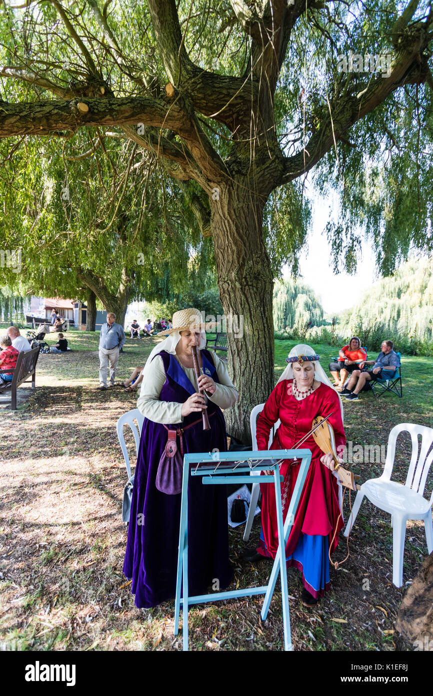 Inghilterra, sandwich. Storia viva giocatori, due donne in costume medievale, in piedi sotto un albero a riproduzione di registratore e rebec, ribalta-runner per il violino. Foto Stock