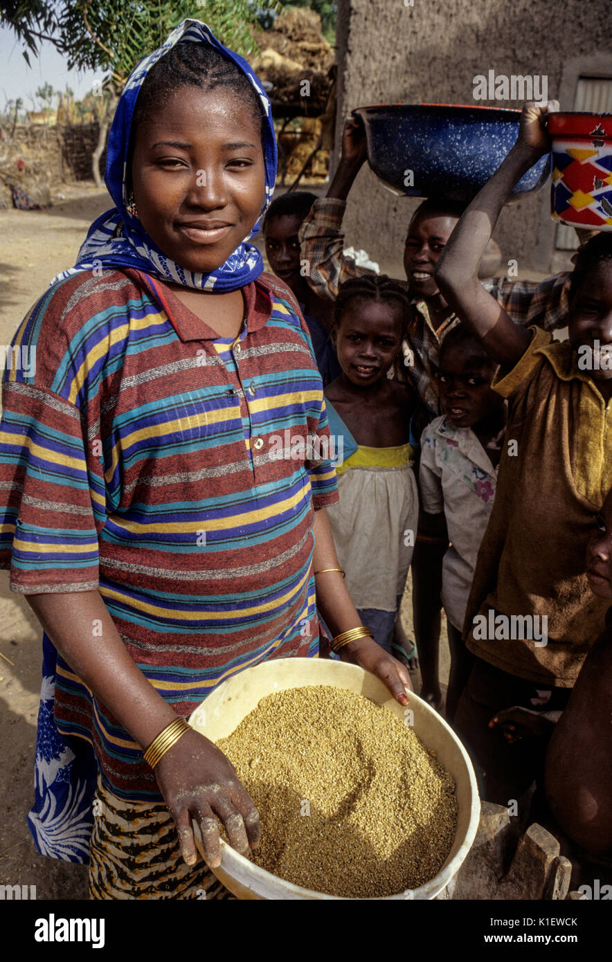 Niger, Tonkassare, Africa occidentale. Giovane donna Zarma con calabash di miglio. Foto Stock