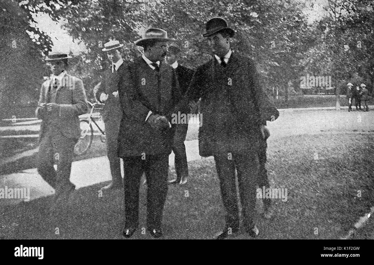 Theodore Roosevelt, allora Vice Presidente degli Stati Uniti, sta con Giovanni G Milburn in un parco, altri uomini stavano in piedi nelle vicinanze, Buffalo, New York, 1901. Foto Stock
