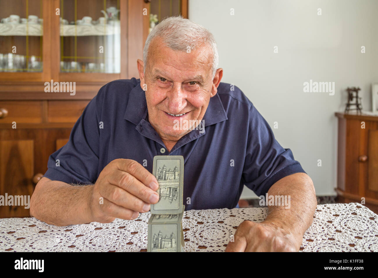 Il vecchio uomo sorridente e scheda edificio torre dentro la sua casa Foto Stock