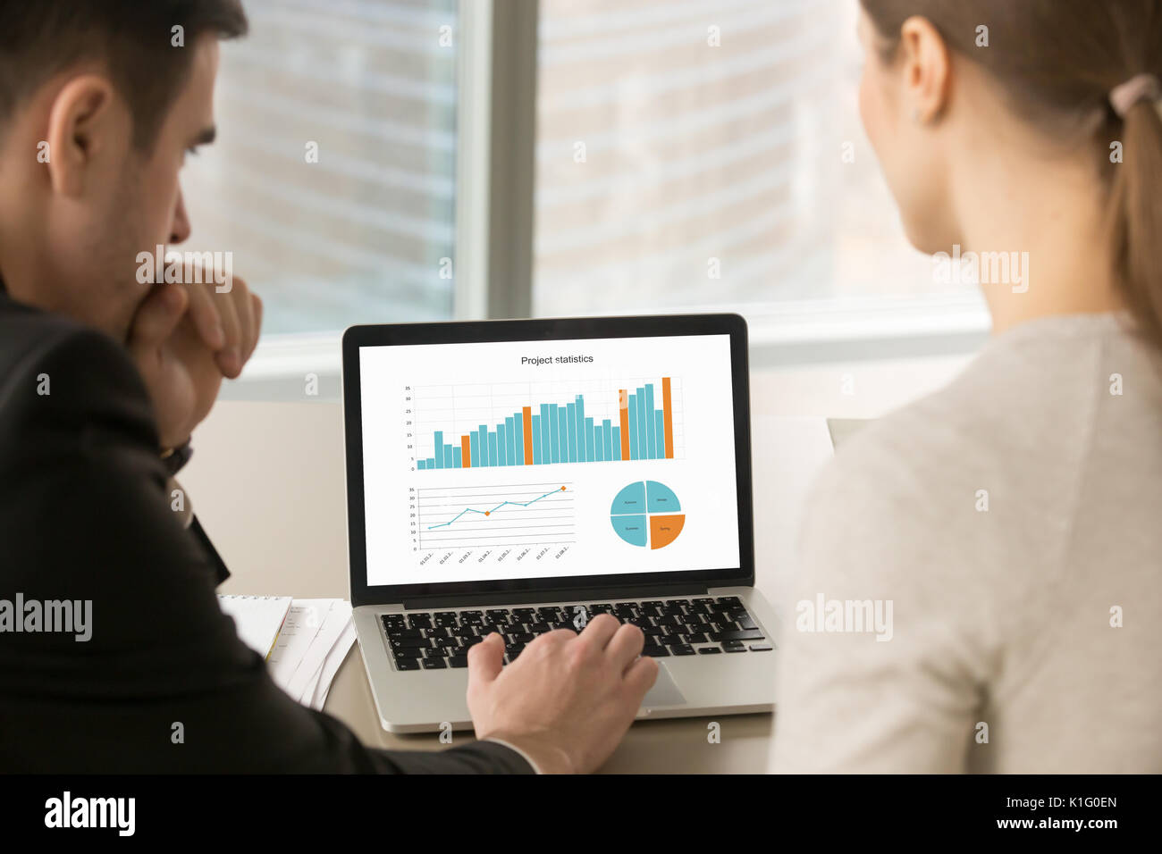 Il team di Business analizzando i dati delle statistiche su schermo portatile, uomo di progetto Foto Stock