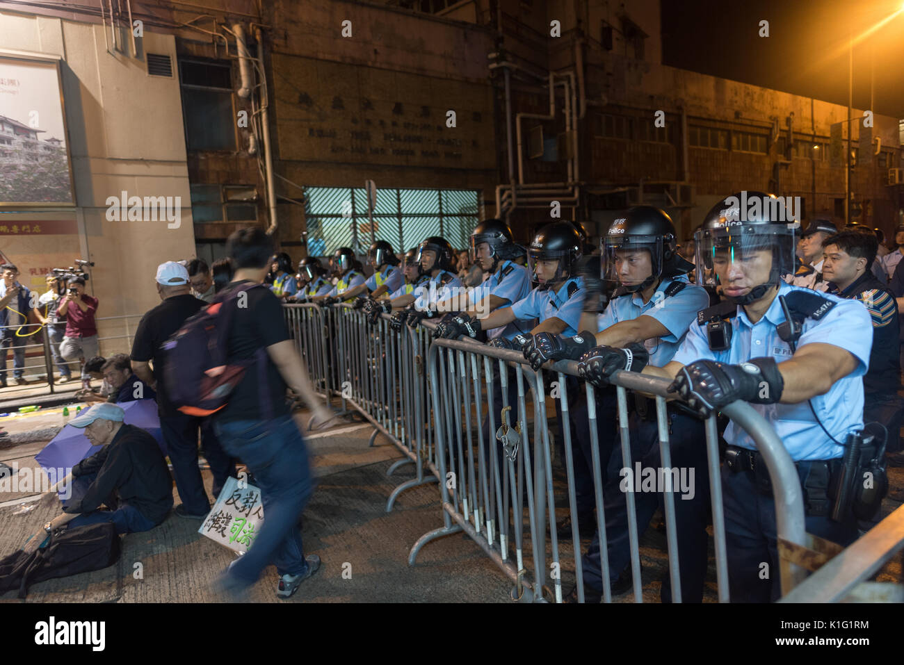 Poliziotti uomo una barricata prima di manifestanti a Oathgate proteste nel novembre 2016 a Hong Kong Foto Stock