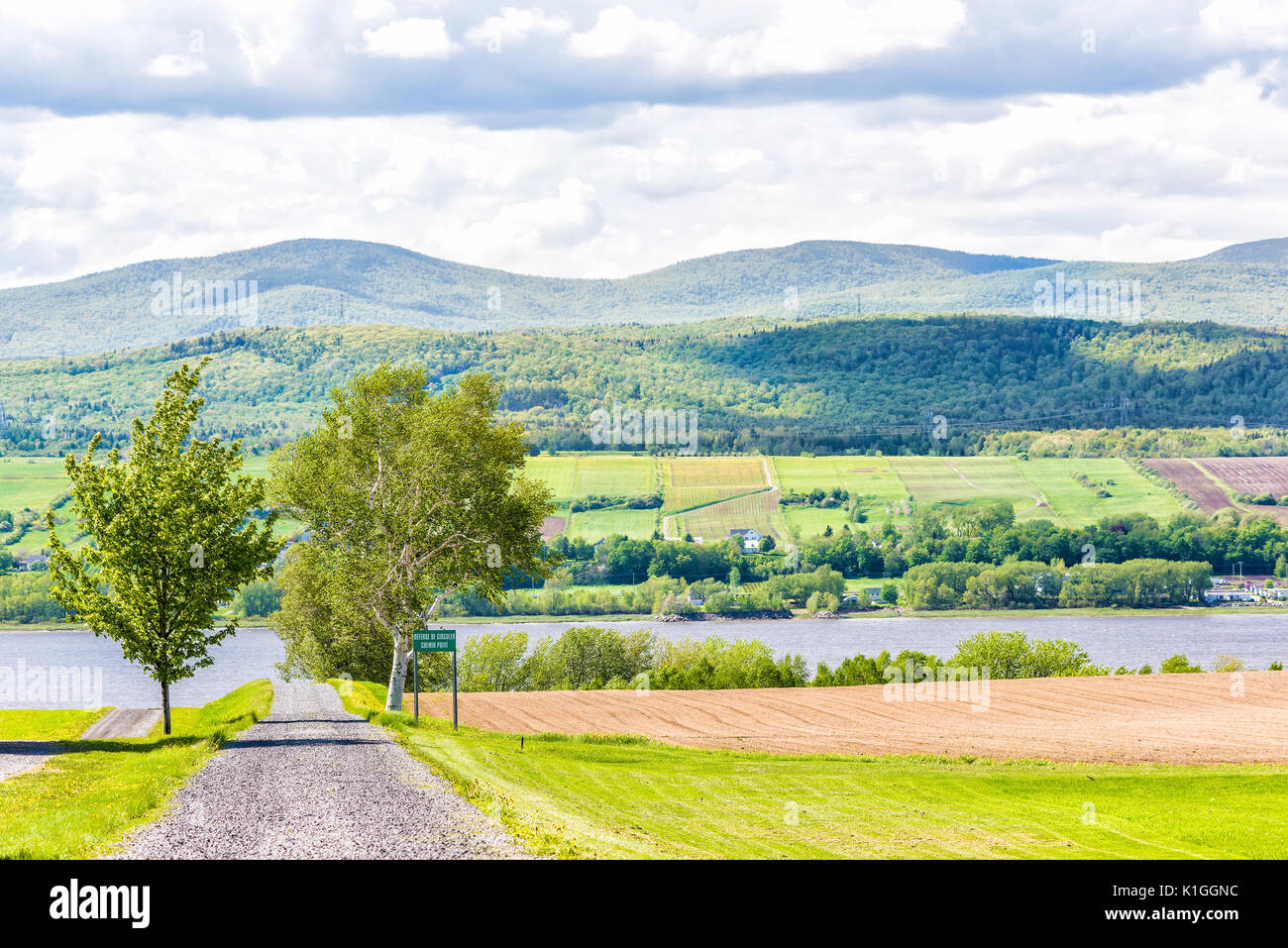 Ile D'Orleans, Canada - 1 Giugno 2017: Paesaggio con campo arato in estate e il sentiero percorso strada con accesso privato Foto Stock