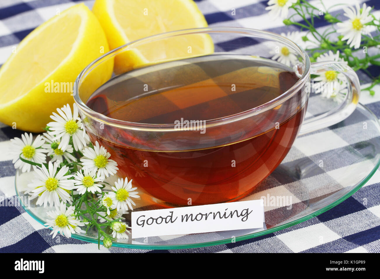 Buona mattina card con tazza di tè, camomilla fiori e di limone fresco Foto Stock