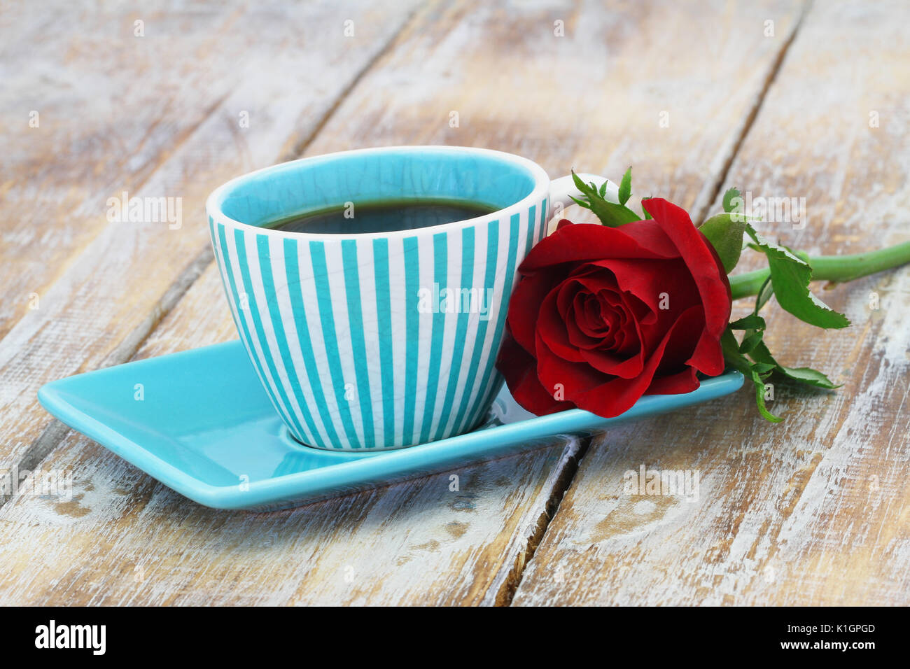 Tazza di caffè con una rosa rossa su un lato con spazio di copia Foto Stock