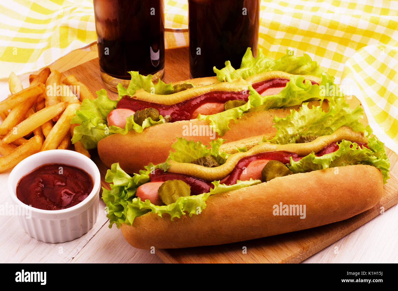 Barbecue grigliate di hot dog e patatine fritte e cola su una scheda di cucina Foto Stock