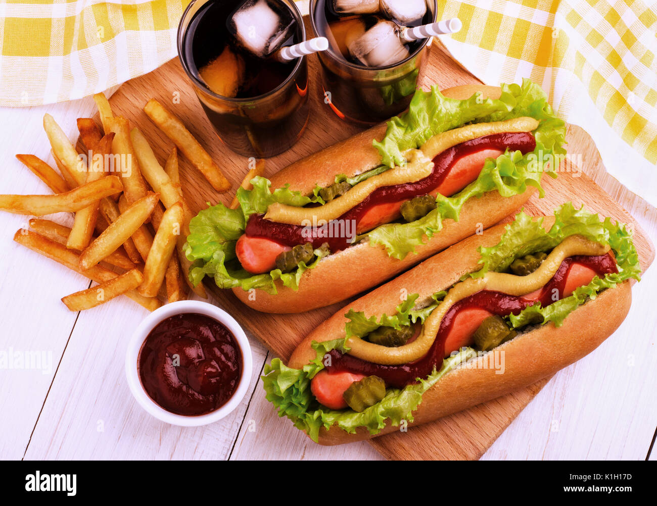 Hot Dogs, Spicchi di patate e cola sulla tavola di legno, vista dall'alto. Fast food. Foto Stock