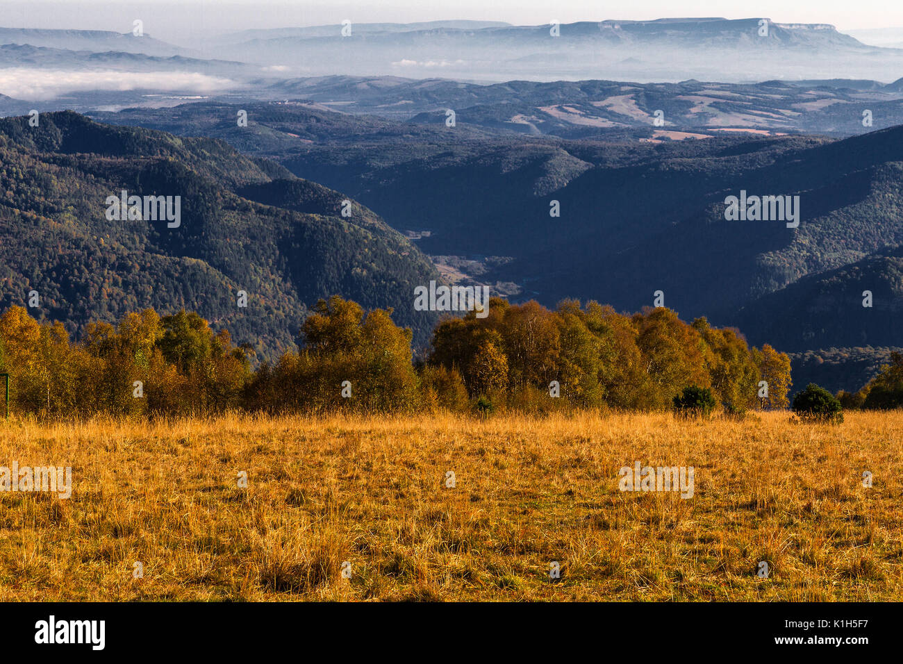 La natura specifica di stagione paesaggio: zona di montagna da autunno con discese coperte da asciutto erba gialla e vista aerea sui monti lontano. Caucaso ri Foto Stock