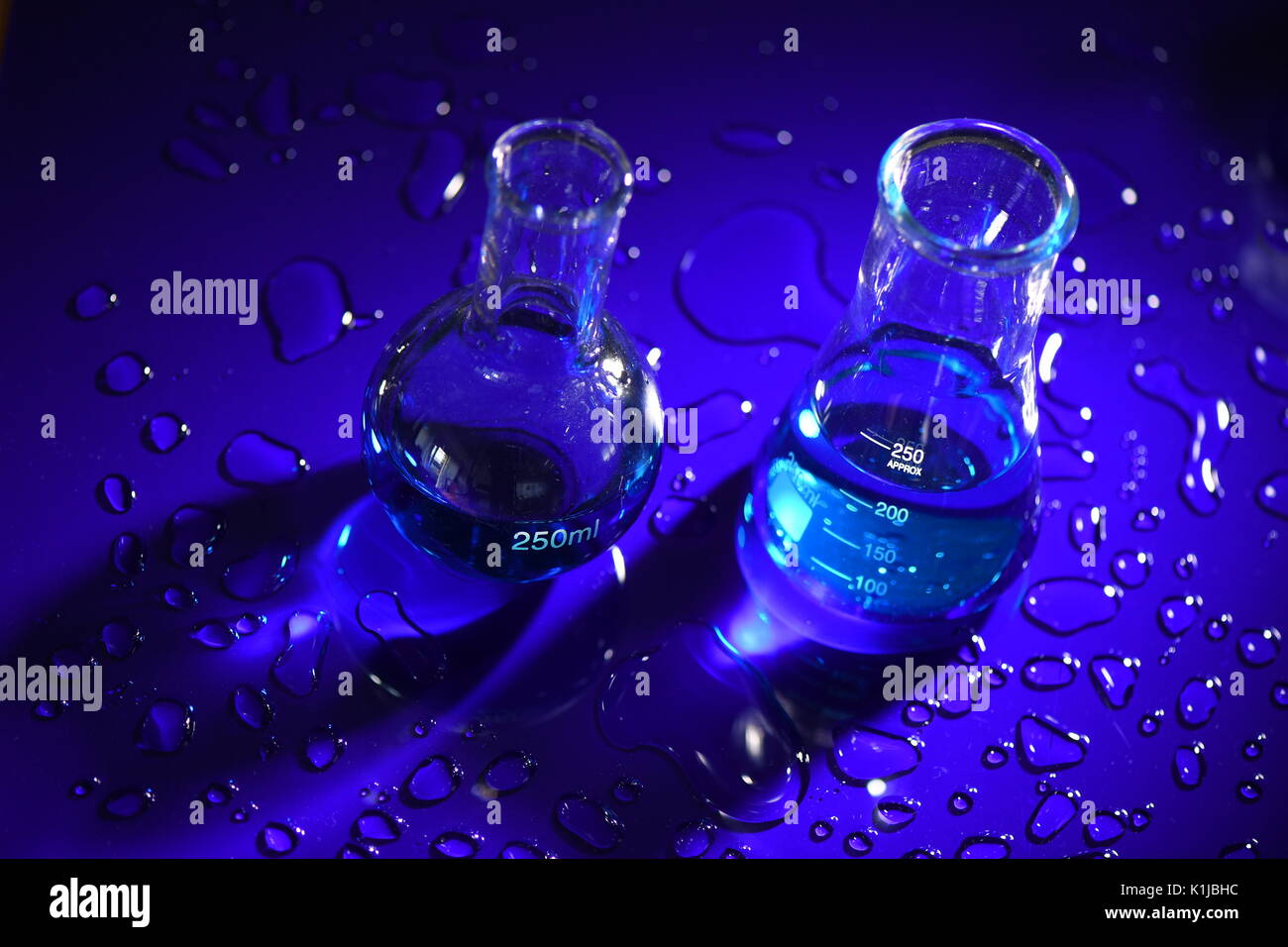 Laureato scienza conica bicchieri sulla acrilica blu Foto Stock