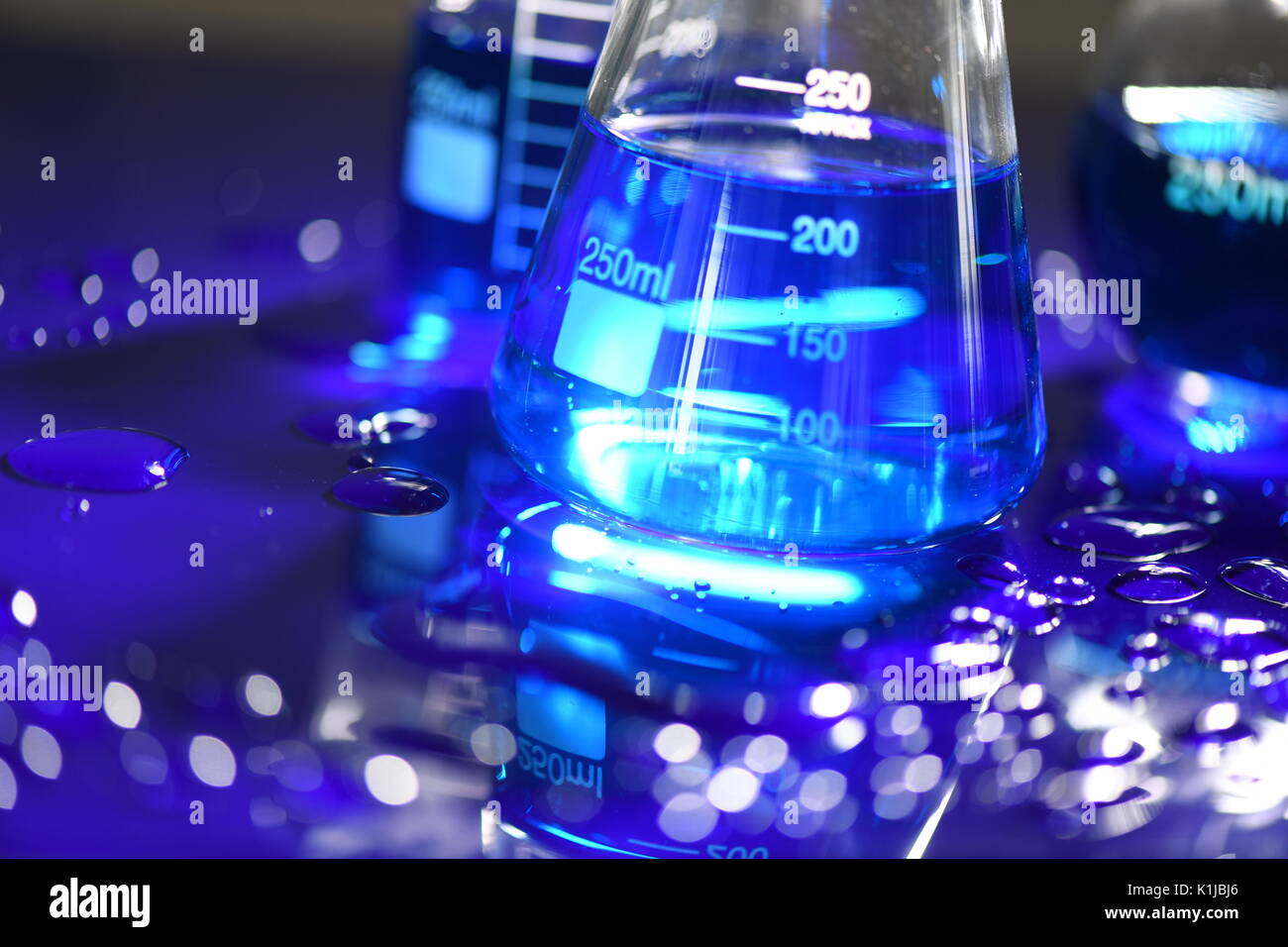 Laureato scienza conica bicchieri sulla acrilica blu Foto Stock